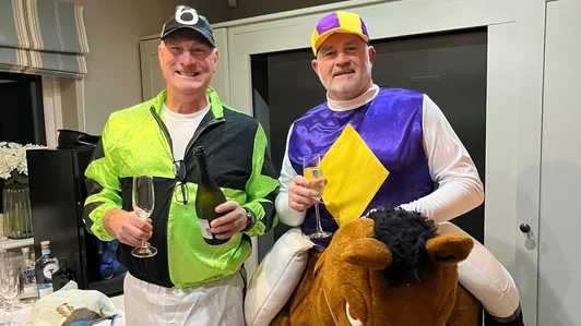 Sussex Race Nights hosts in colourful jockey silks celebrating with a toy horse mascot